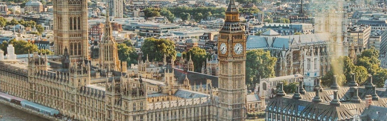 Stunning aerial view of London's iconic Big Ben and the river Thames under daylight.